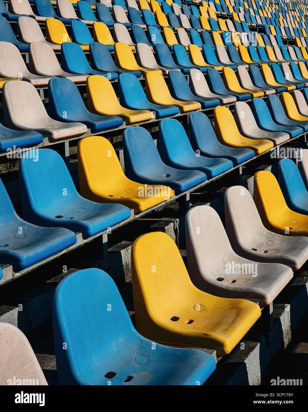 Stadio vuoto - posti sporchi in tribuna. File di posti gialli, blu e bianchissimi in uno stadio Foto Stock