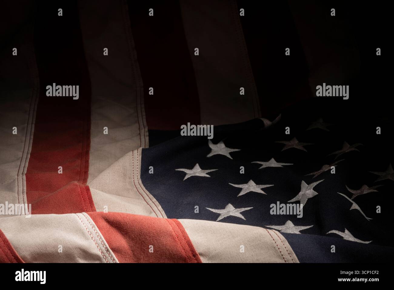 Primo piano del tessuto della bandiera americana con pieghe e cuciture visibili, per una texture di fondo patriottica pulita. Foto Stock