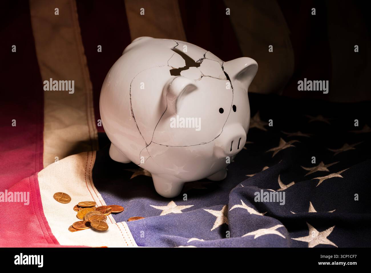 Un salvadanaio bianco mal riparato posto sulla bandiera americana circondato da penny sparsi. Foto Stock