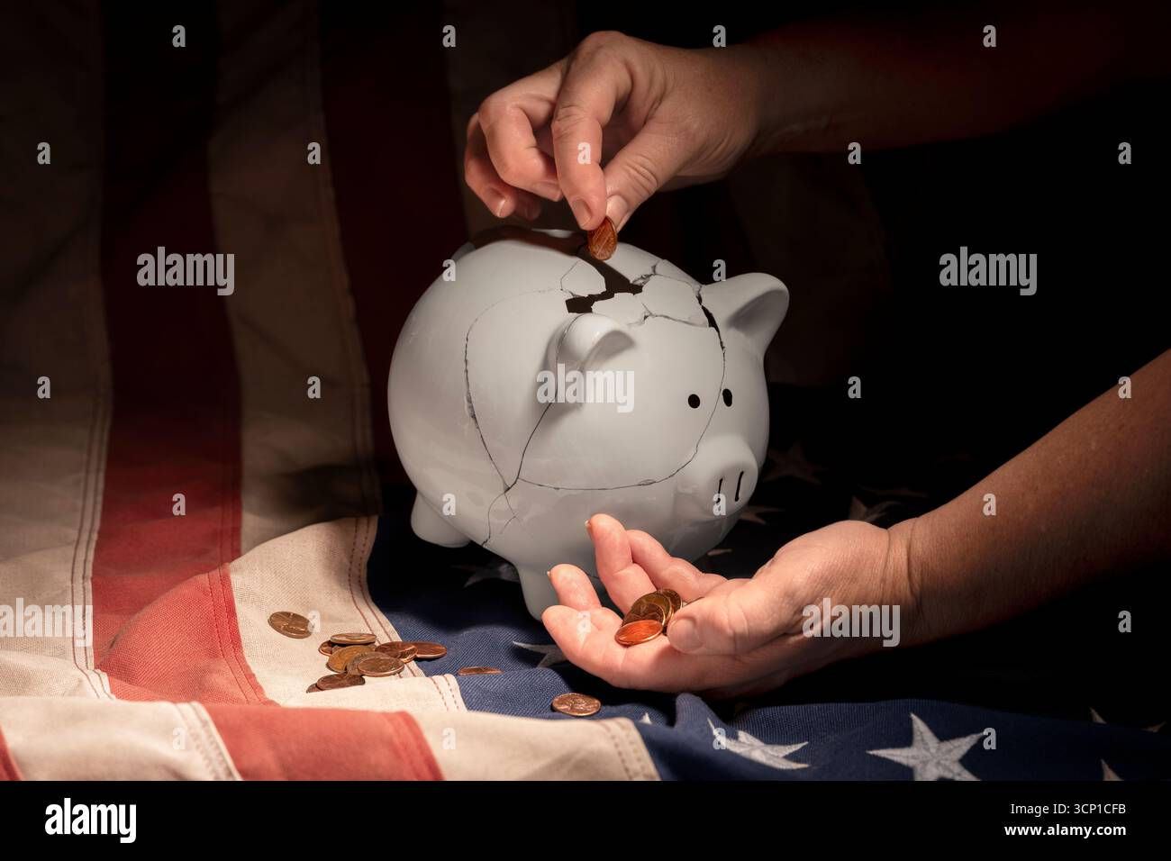 Primo piano di mani femminili più anziane, una che tiene le monete, l'altra colloca un penny in un salvadanaio bianco riparato sulla bandiera americana. Foto Stock