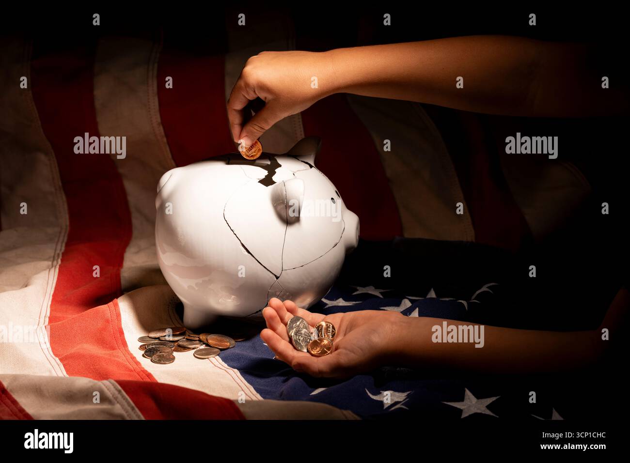 Primo piano delle mani di un bambino maschio che spinge una banconota da un dollaro in un salvadanaio bianco riparato sulla bandiera americana. Foto Stock