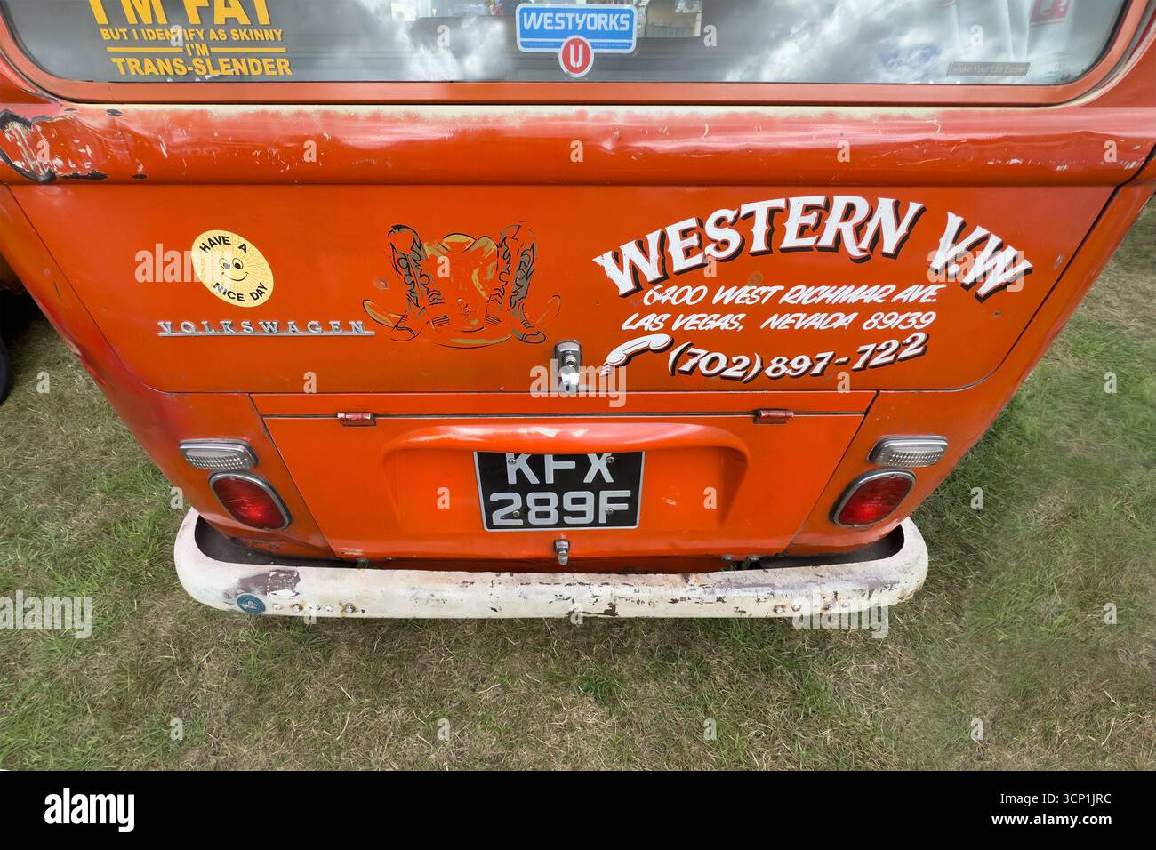 Vista posteriore di un classico furgone Volkswagen tipo 2 arancione con illustrazioni personalizzate di Las vegas, targa e segnaletica in una mostra di auto d'epoca. - Immagine stock catturata con smartphone
