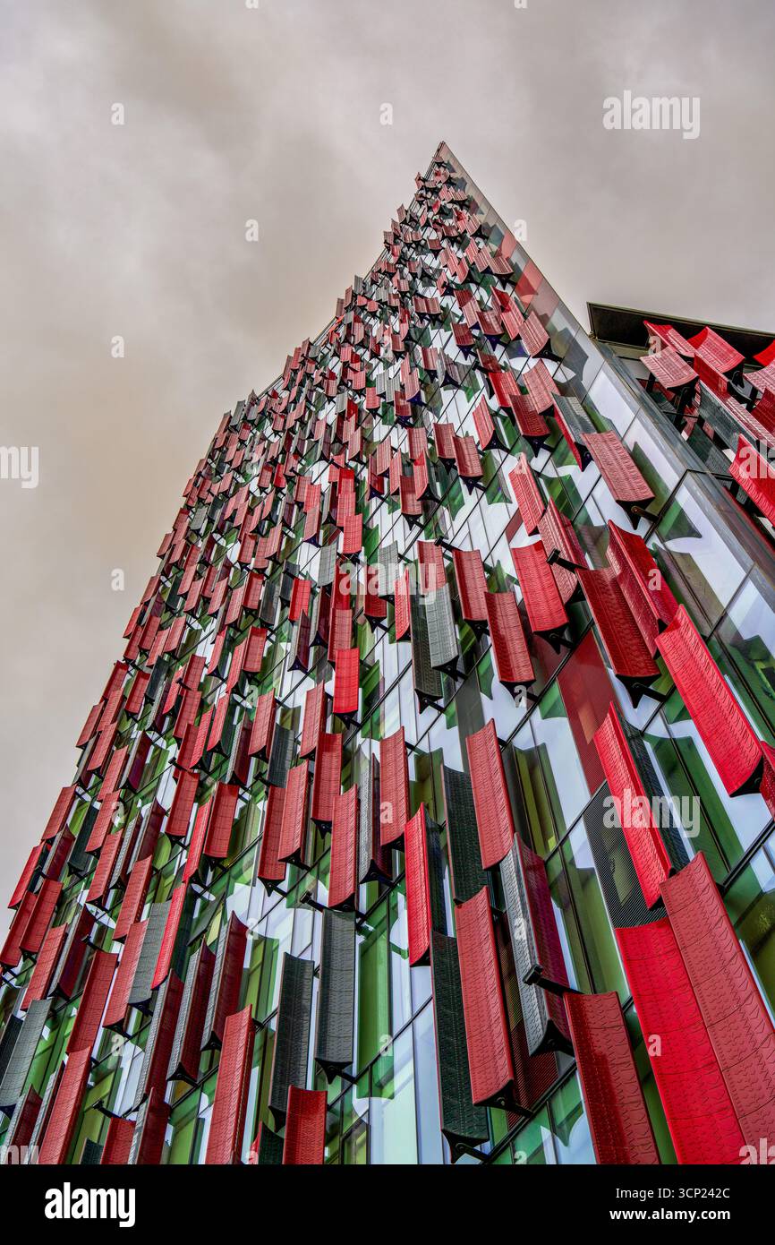 Moderno edificio futuristico con pannelli geometrici rossi e neri su facciata in vetro a Tirana, Albania - architettura urbana contemporanea Foto Stock