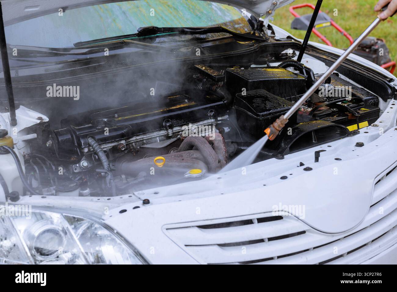 Pulizia del motore dell'auto con vapore per prestazioni di manutenzione migliori. Foto Stock