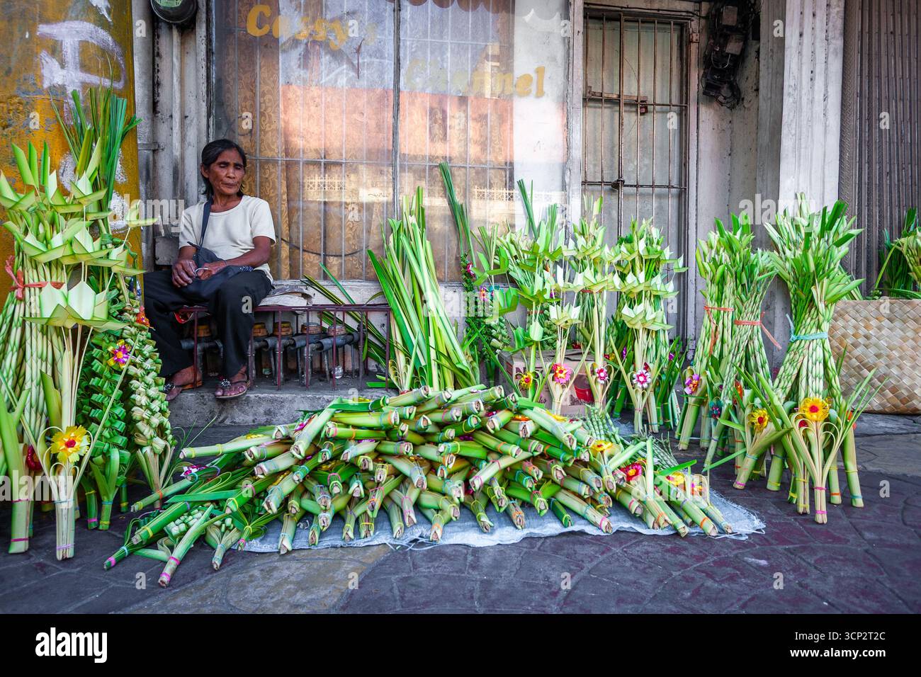 Corone artistiche frontali di palme da cocco in vendita fuori da una chiesa durante la domenica delle Palme a Manila, Filippine Foto Stock