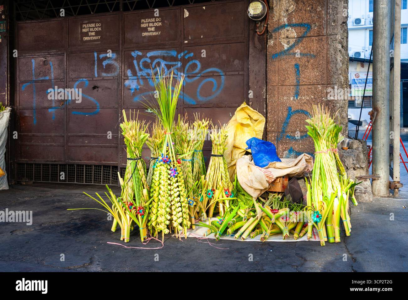 Corone artistiche frontali di palme da cocco in vendita fuori da una chiesa durante la domenica delle Palme a Manila, Filippine Foto Stock