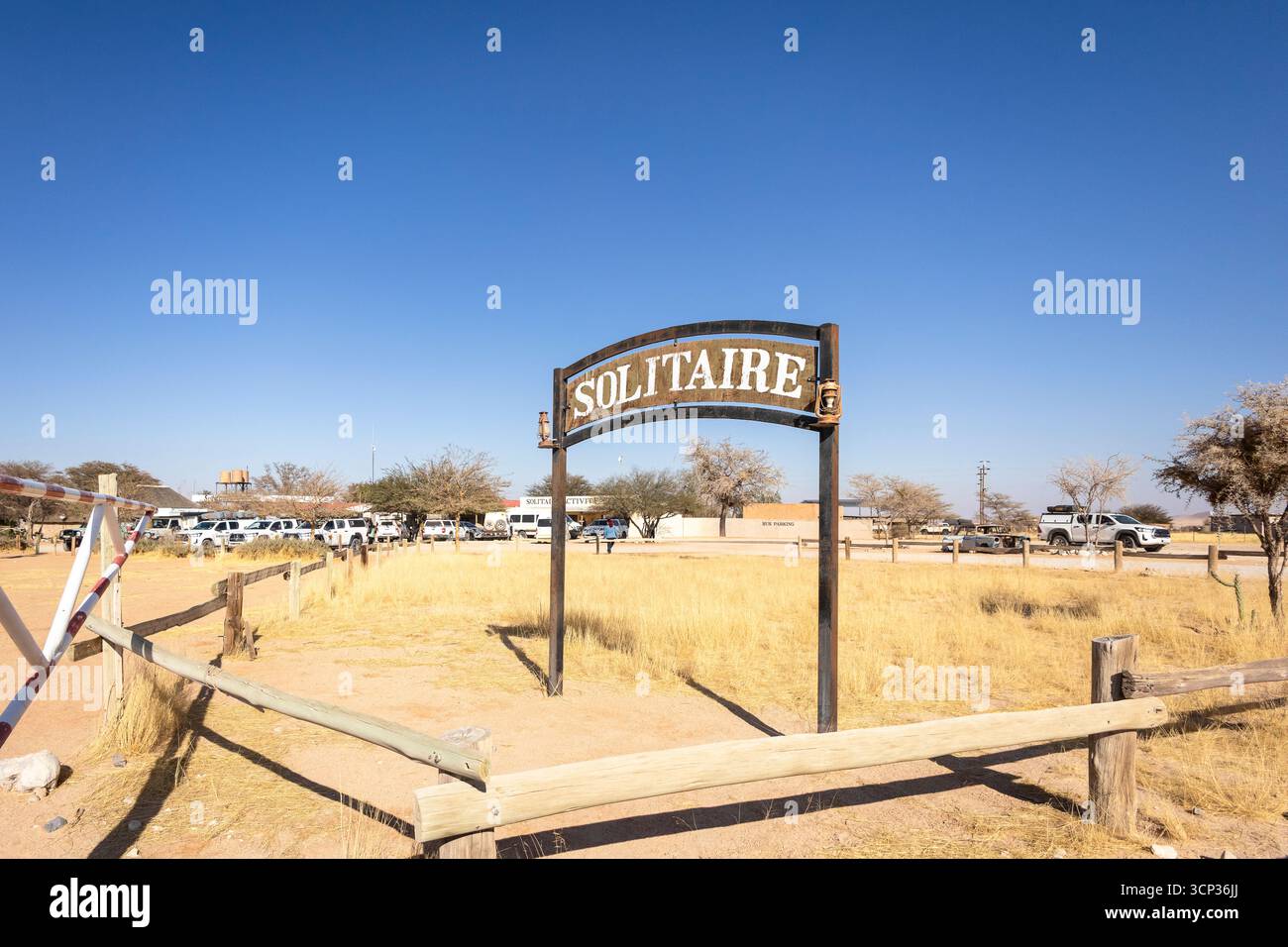 Il remoto insediamento desertico di Solitaire in Namibia, 27 agosto 2025: Presenta un cartello con il nome della città, adagiato su dune di sabbia dorata e ru Foto Stock