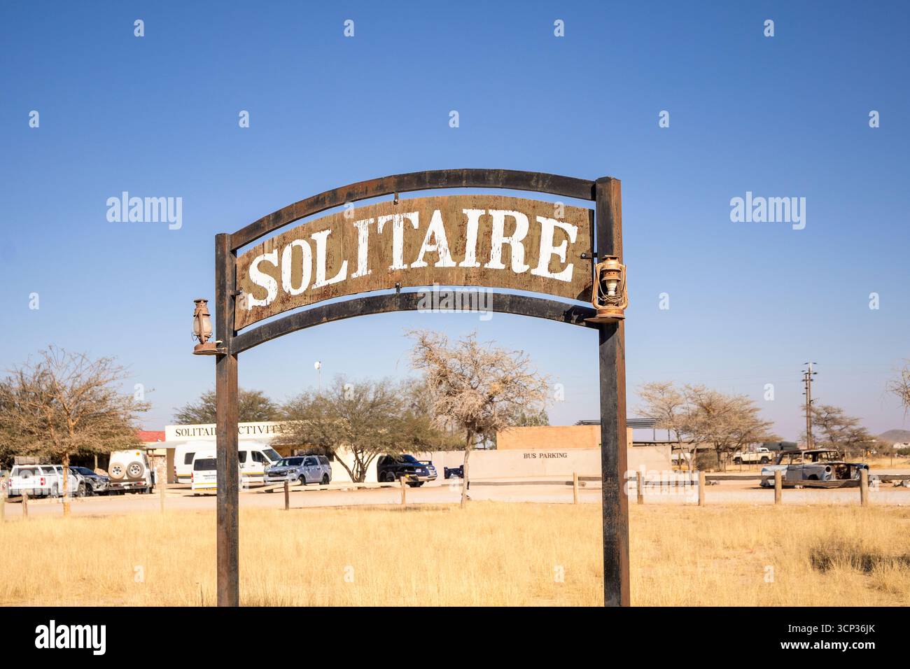 Il remoto insediamento desertico di Solitaire in Namibia - 27 agosto 2025: Presenta un cartello con il nome della città, adagiato su dune di sabbia dorata e. Foto Stock