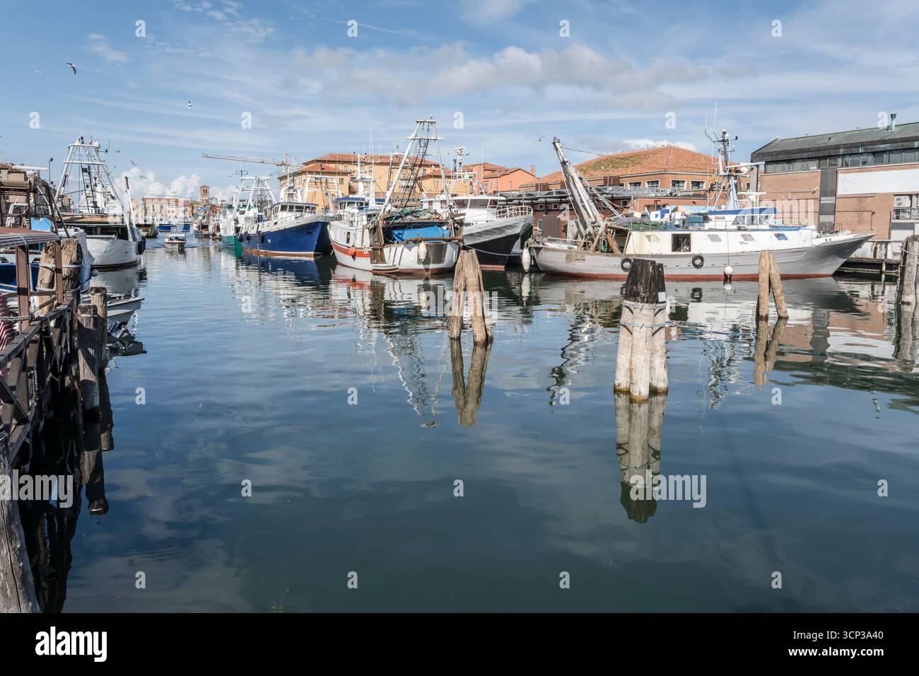 Paesaggio urbano con pescherecci ormeggiati nel canale S.Domenico, girato alla luce dell'estate a Chioggia, Veneto, Italia Foto Stock