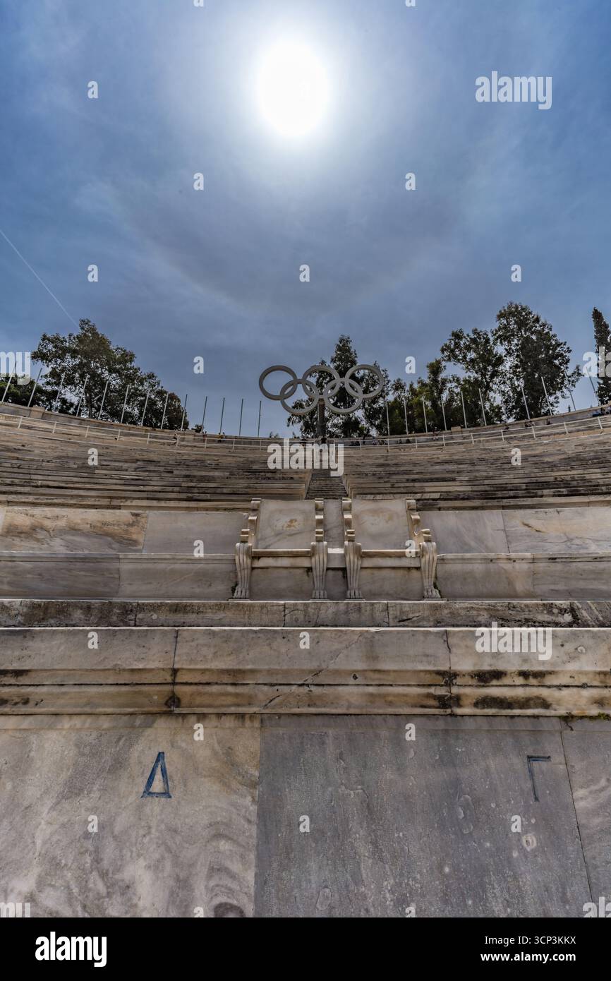 File in marmo dello Stadio Panatenaico di Atene, Grecia, con il cartello degli anelli olimpici sopra. Maggio. 2025. Foto Stock