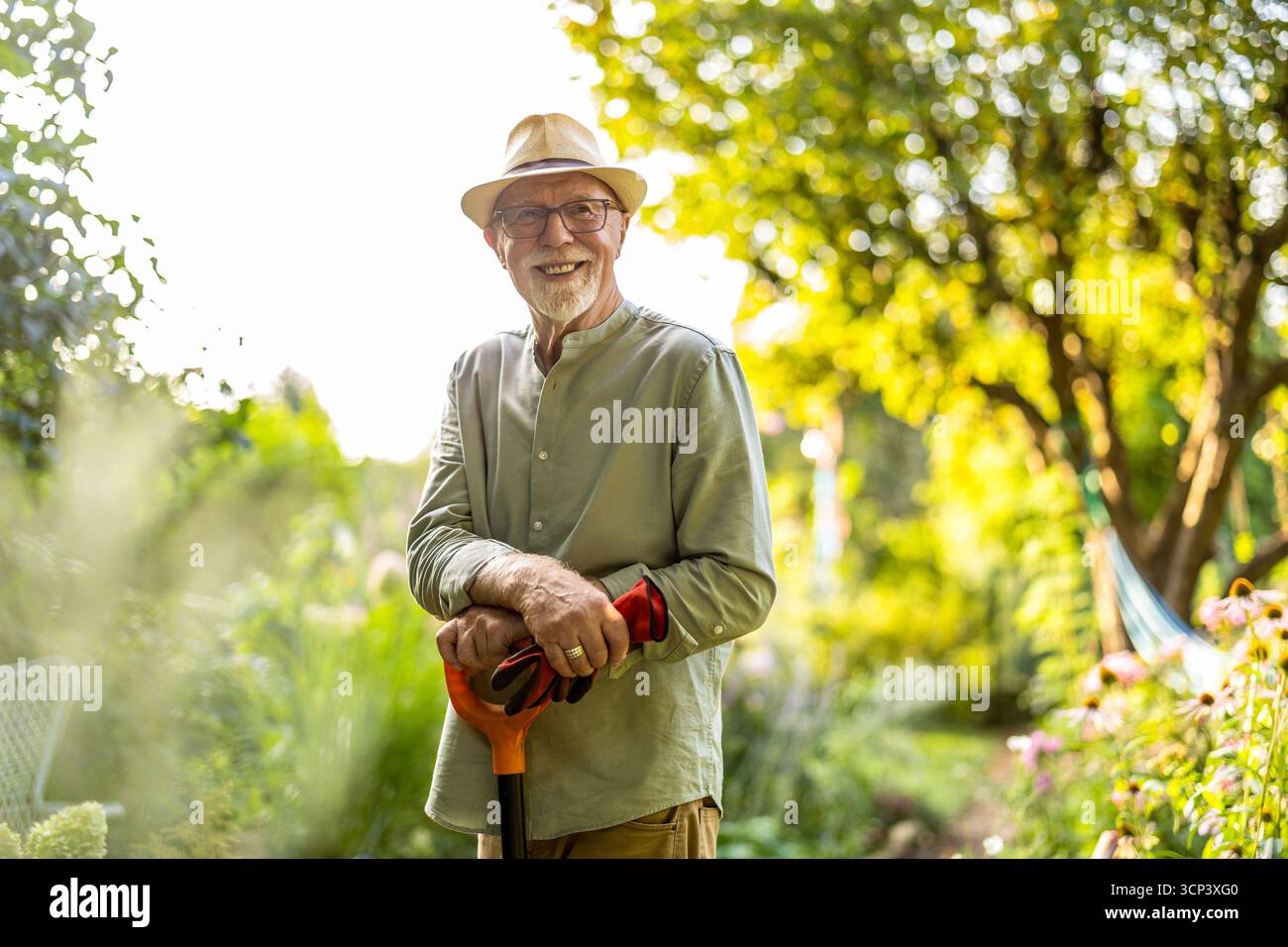 Uomo anziano in giardino durante il giorno d'estate Foto Stock
