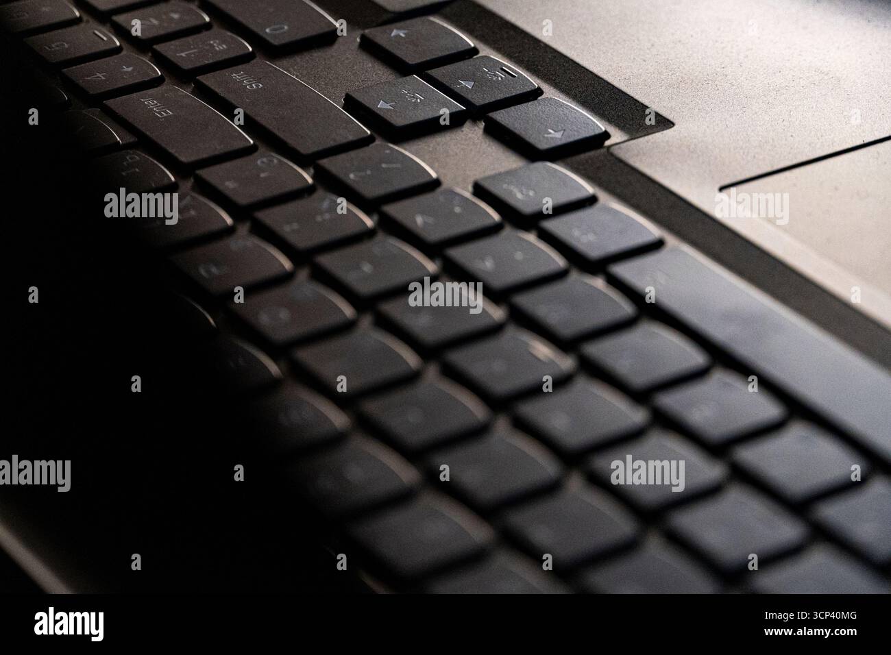 Foto macro di una moderna tastiera per laptop in una luce calda e soffusa. Perfetto per concetti di tecnologia, lavoro a distanza, apparecchiature per ufficio o comunicazione digitale Foto Stock