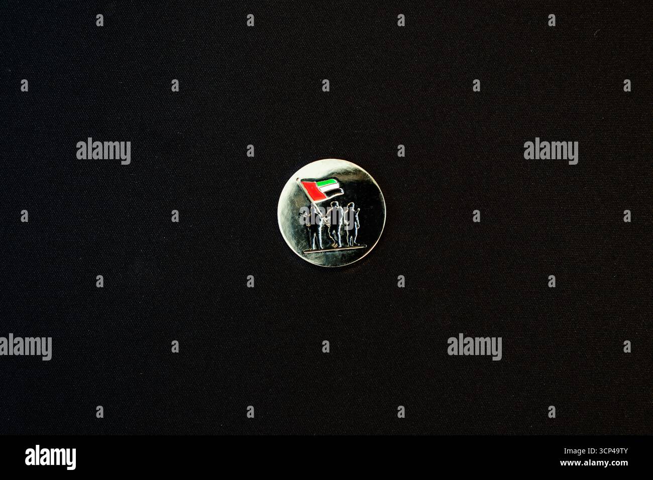 Spilla rotonda per il giorno nazionale degli Emirati Arabi Uniti con sagome di soldati che innalzano la bandiera degli Emirati Arabi Uniti Foto Stock
