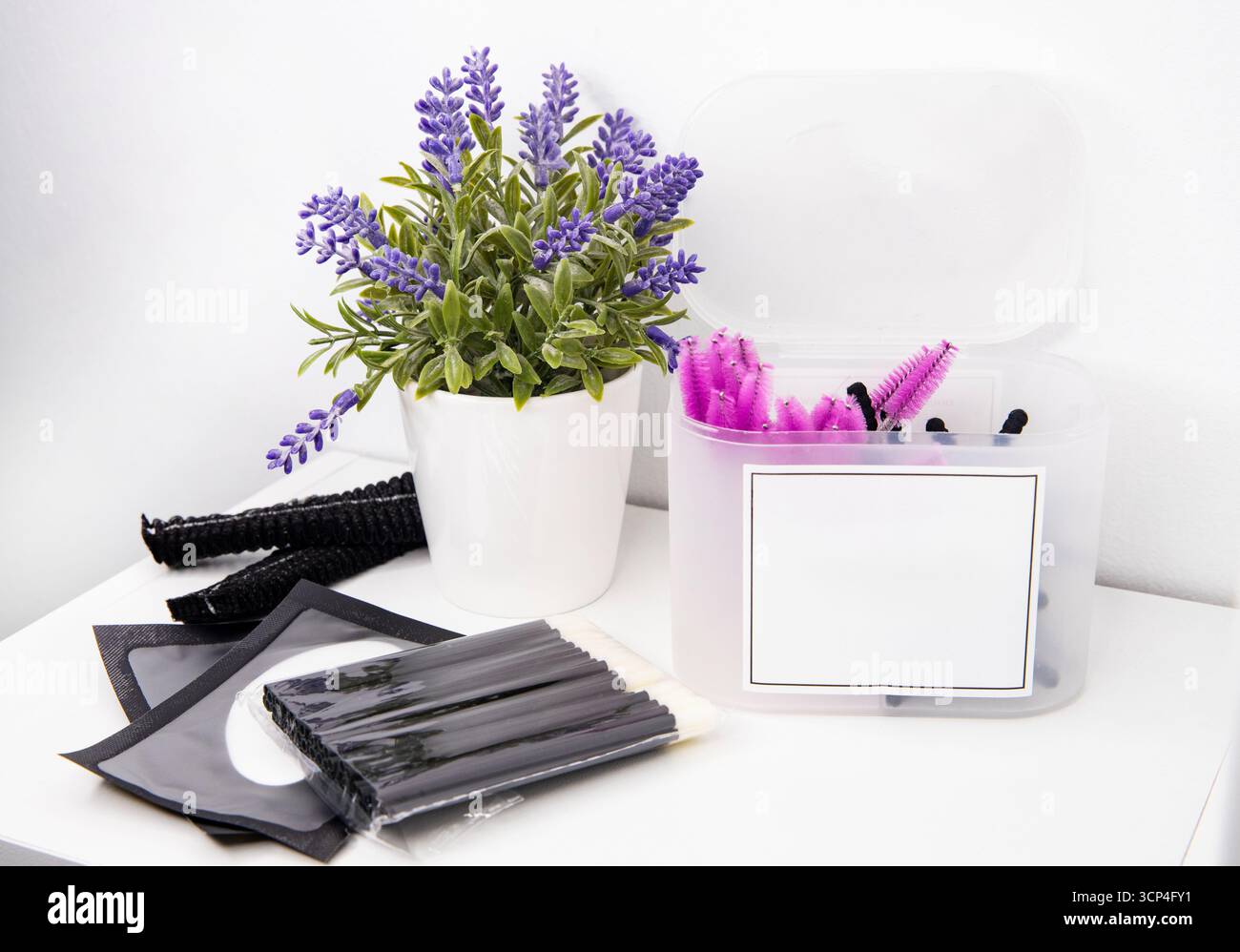 Forniture cosmetiche con un vaso di fiori di lavanda. Pennelli per il trucco e accessori, spazio per il testo Foto Stock