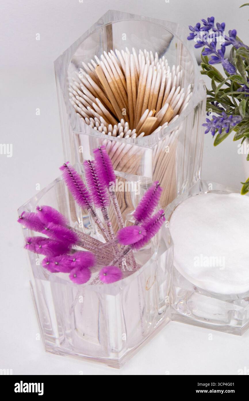 Primo piano di un organizzatore cosmetico. Tamponi di cotone e spazzole rosa per ciglia e sopracciglia Foto Stock