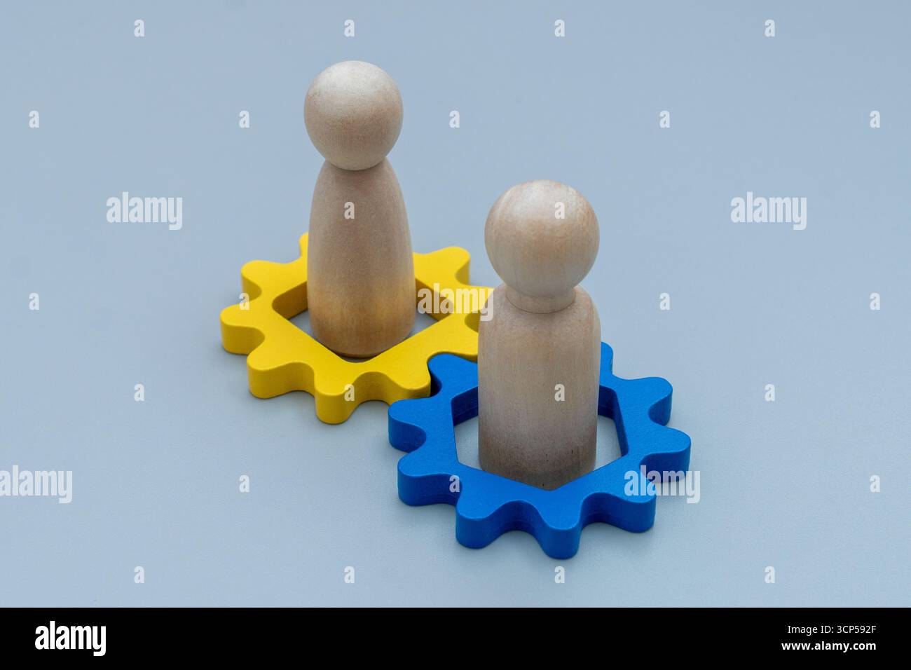 Due figure umane di legno e attrezzatura di legno. Lavoro di squadra, cooperazione, collaborazione, partnership, leadership, e lavorare insieme. Foto Stock