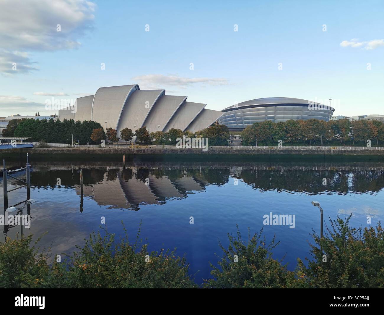 Pacific Quay, Glasgow: OVO Hydro, Armadillo e Finnieston Crane riflettono il moderno skyline e il passato dei cantieri navali della città sul fiume Clyde. Scozia urbana. Foto Stock