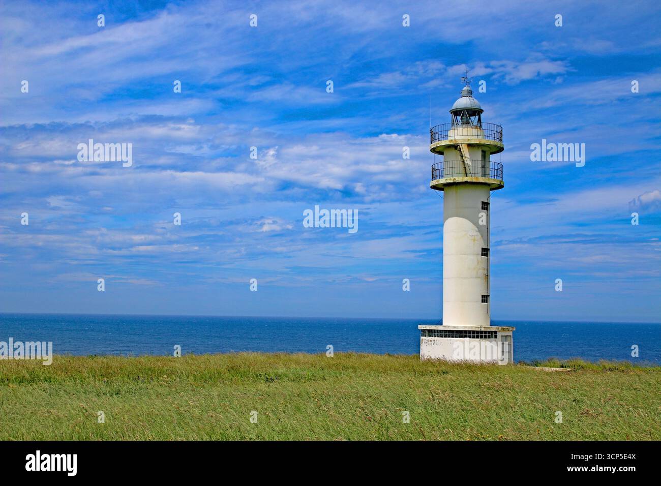 Un faro arroccato sulla cima di una scogliera che si affaccia sull'Oceano Atlantico, sull'aspra costa settentrionale della Spagna. Foto Stock