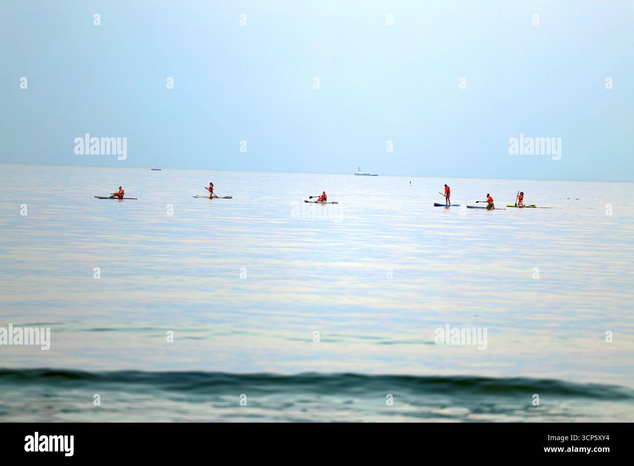 Pagaie sul mare calmo al crepuscolo Foto Stock