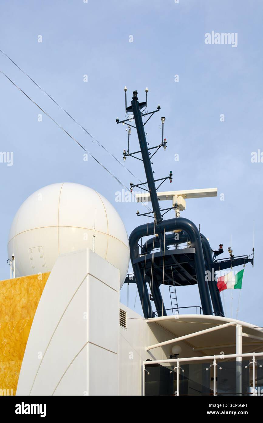 Primo piano dell'albero di navigazione e comunicazione di un'imbarcazione moderna, con un grande radome satellitare, uno scanner radar e antenne contro il cielo. Foto Stock