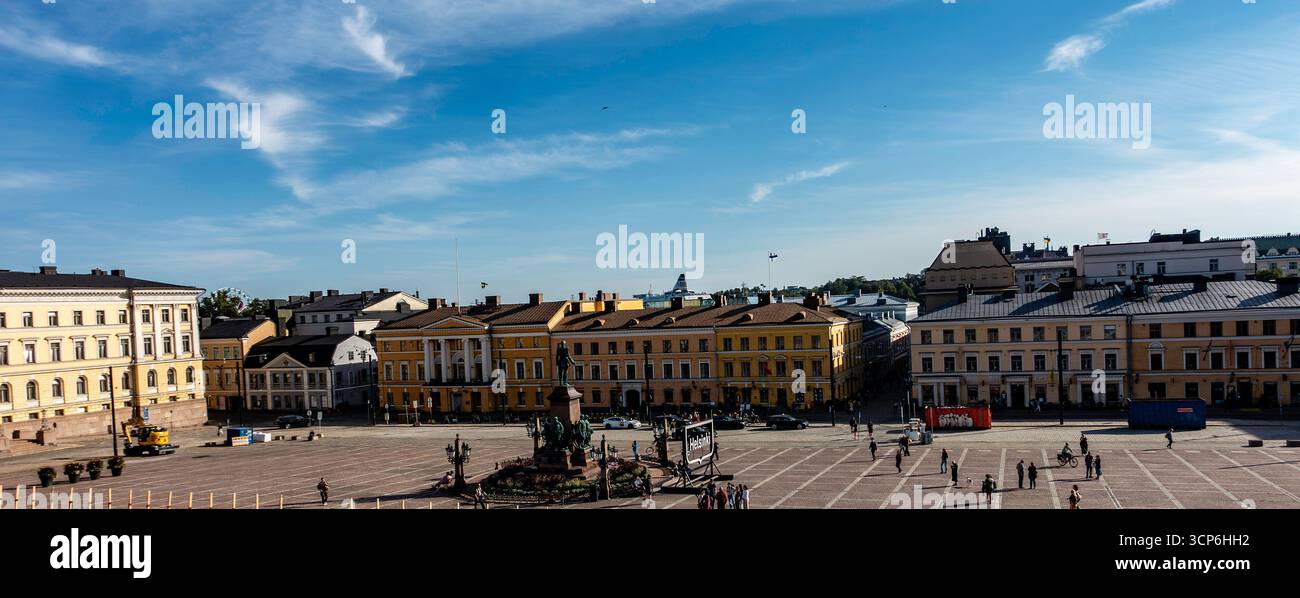 Piazza del Senato a Helsinki, Finlandia, con la statua di Alessandro II, circondata da edifici neoclassici e da spazi pubblici aperti sotto cieli blu. Foto Stock