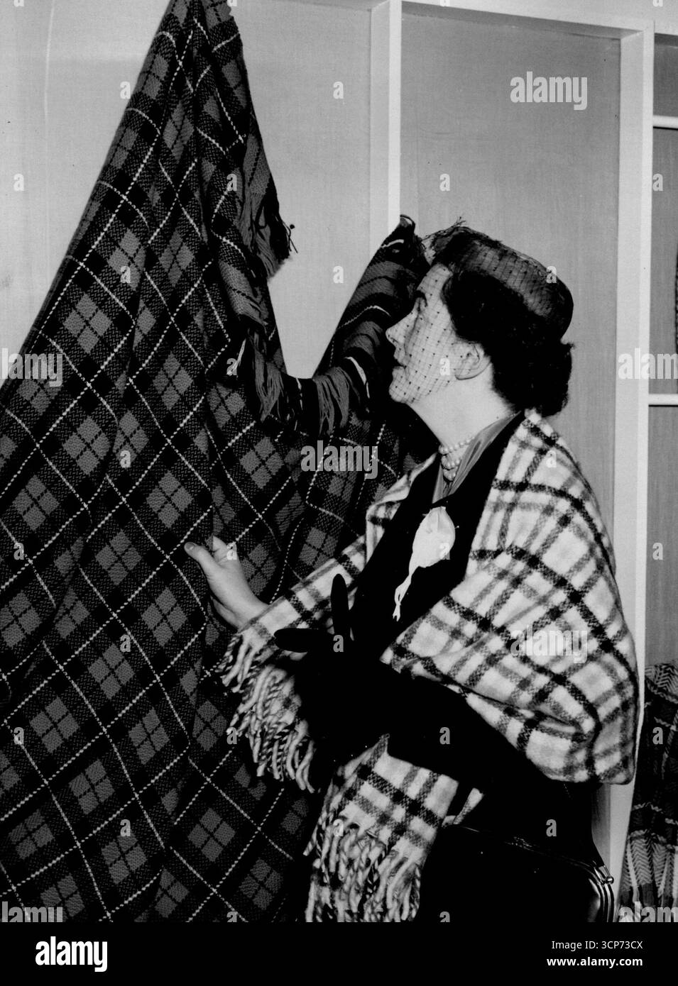 Le Highland Industries vengono a Londra -- la contessa di Dalhousie indossa una stola a plaid, tessuta nell'isola di Skye, esaminando uno scialle plaid alla Highland Home Industries Exhibition di questa mattina. Highland home Industries, in questa settimana, organizza una mostra e vendita di sei giorni presso il centro del tè, Regent Street, dove si trovano bellissimi prodotti fatti a mano dallo scozzese ***** E le isole occidentali sono in vista. Per i crofter scozzesi nelle loro case solitarie, loro di guadagnarsi da vivere nei loro distretti di casa, fermando così la deriva verso la città e lo spopolamento finale delle Highlands. Si mantiene anche in vita Foto Stock