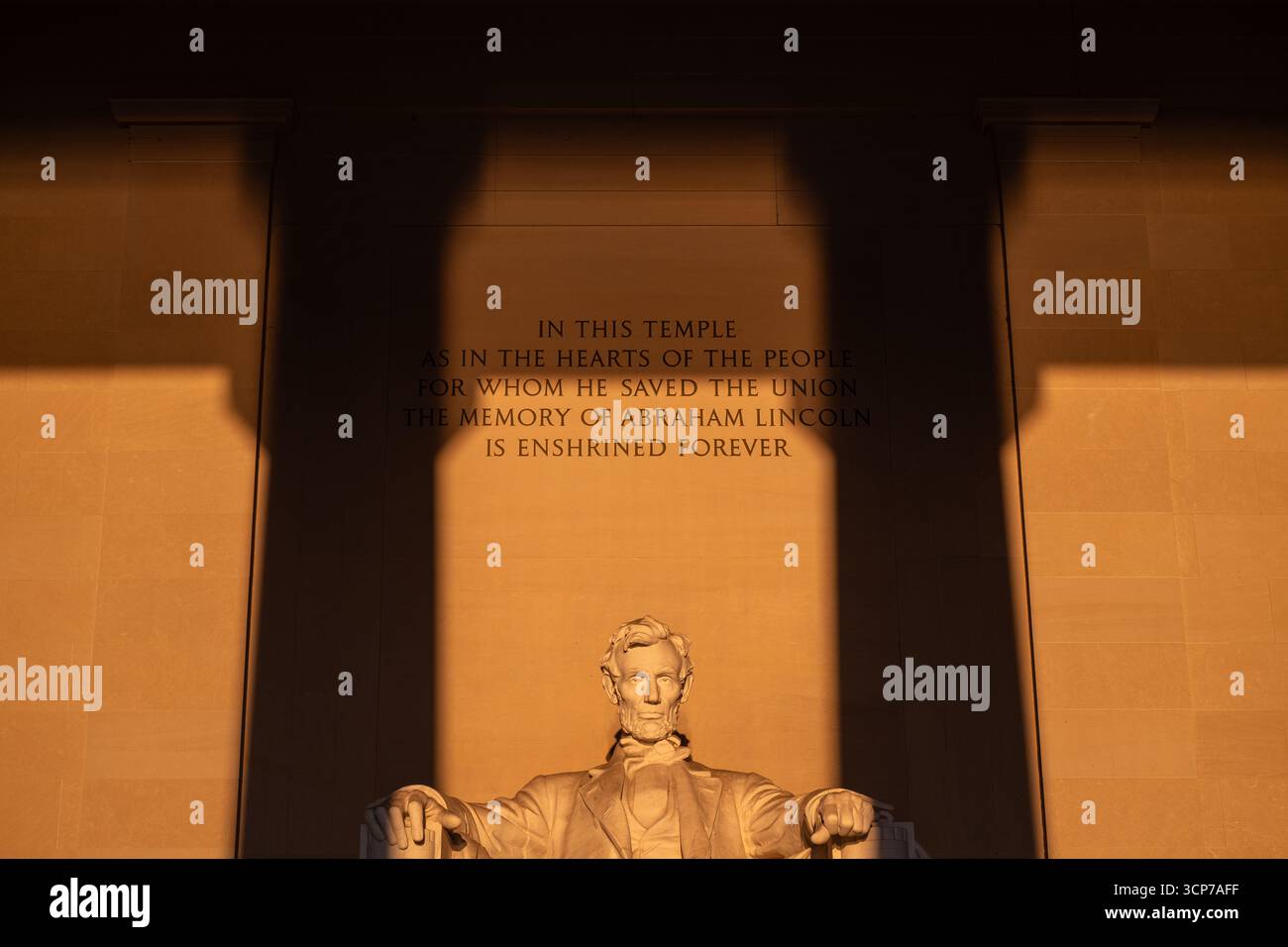Statua del Lincoln Memorial Sunrise Washington DC // WASHINGTON DC - la statua del Lincoln Memorial è illuminata dal caldo bagliore dell'alba, con la luce del sole che scorre direttamente nella camera principale e sulla scultura. Questo fenomeno si verifica durante l'equinozio vernale, quando il sole sorge proprio ad est. L'iscrizione sul muro dietro la statua recita: "IN QUESTO TEMPIO COME NEI CUORI DEL POPOLO PER IL QUALE HA SALVATO L'UNIONE, LA MEMORIA DI ABRAHAM LINCOLN È CONSACRATA PER SEMPRE". Il Lincoln Memorial, un importante monumento nazionale, onora il sedicesimo presidente degli Stati Uniti. Foto Stock
