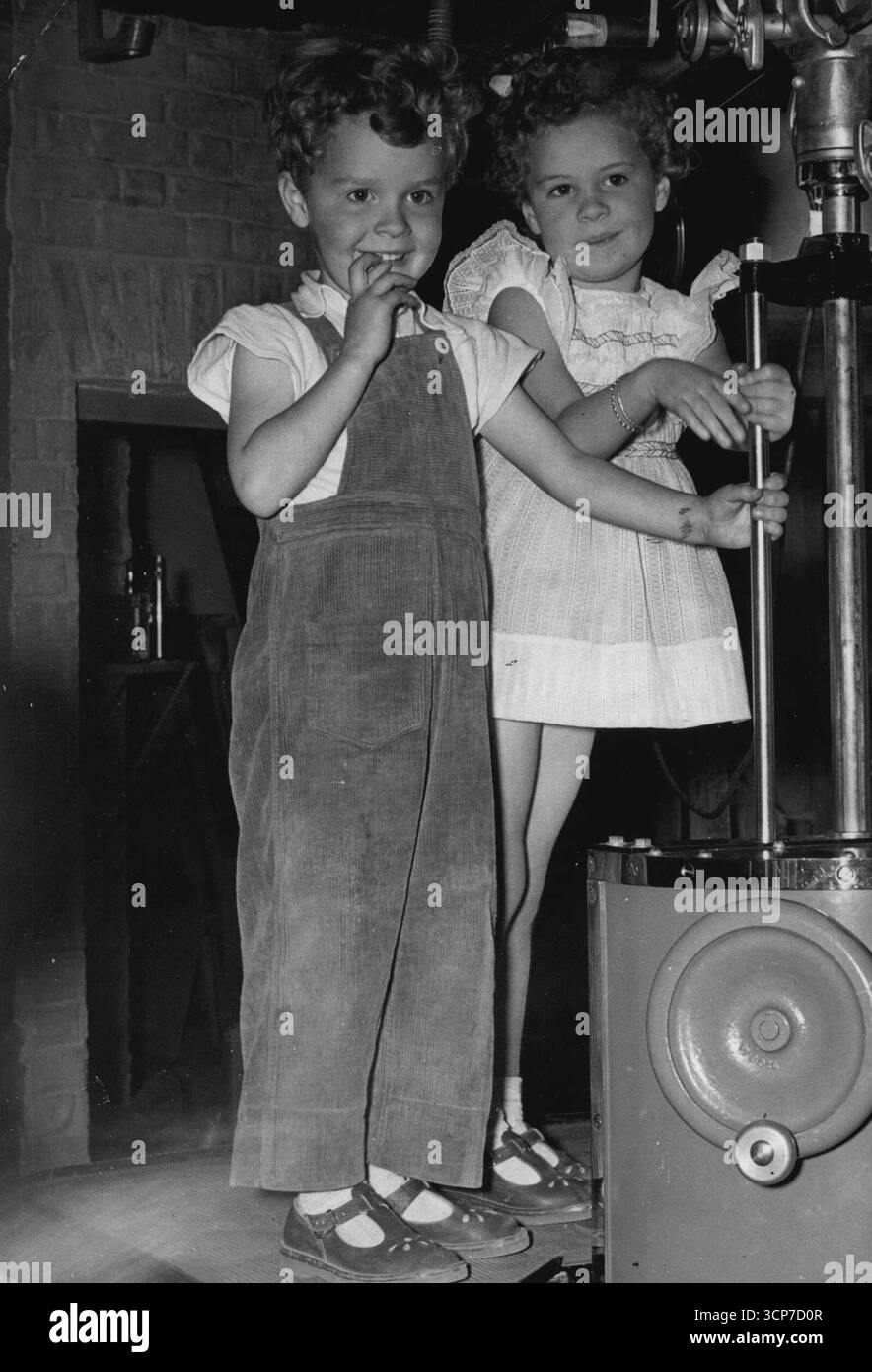 C'è sempre qualcosa per Amuse i bambini -- .... In uno studio cinematografico e durante le riprese del nuovo film di Mandy Miller "Raising A Riot" presso gli studi Shepperton, i due figli di Michael Bentine "Gussy" (a destra) e "Fusty" hanno trovato molto per divertirli.i bambini di 5 anni e 5 anni hanno una vista in tribuna su un "Boom" per guardare le riprese. La famiglia Bentine presto andrà in Australia. 14 dicembre 1954. (Foto di Paul Popper, Paul Popper Ltd.). Foto Stock