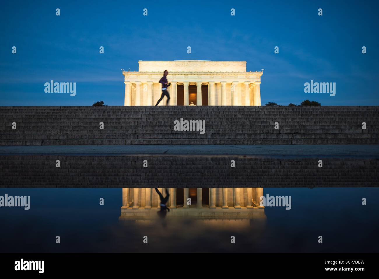 Lincoln Memorial Reflection on Puddle Washington DC // WASHINGTON DC - il Lincoln Memorial si riflette in una pozzanghera sulla piazza di fronte al monumento. Il memoriale neoclassico, dedicato al sedicesimo presidente degli Stati Uniti Abraham Lincoln, è illuminato al crepuscolo. Il memoriale è un importante punto di riferimento nel National Mall di Washington D.C. la sua architettura è ispirata ai templi dorici greci. La piscina riflettente di fronte al monumento è una caratteristica chiave del design del National Mall. Foto Stock