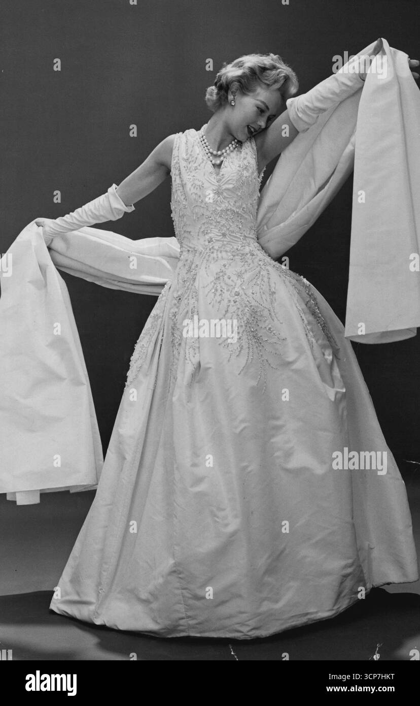 Questo squisito abito da palla Dior è in fail bianco ricamato con stola di faille corrispondente. Gennaio 10, 1955. Foto Stock