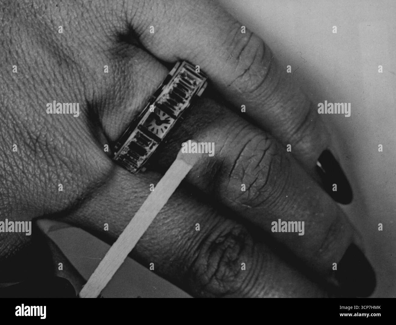 Tempo sulle loro mani non importa quanto siano impegnate le donne possono avere "tempo sulle mani" - tempo sotto forma di una piccola partita, delle dimensioni di una testa, incastonata su un anello e indossata al dito. Questo modello è stato realizzato da un'azienda svizzera leader e esposto alla mostra di orologi e gioielli di Ginevra. Il minuscolo orologio è inserito in un anello di platino, affiancato da diamanti baguette. 8 ottobre 1951. (Foto di Reuterphoto). Foto Stock