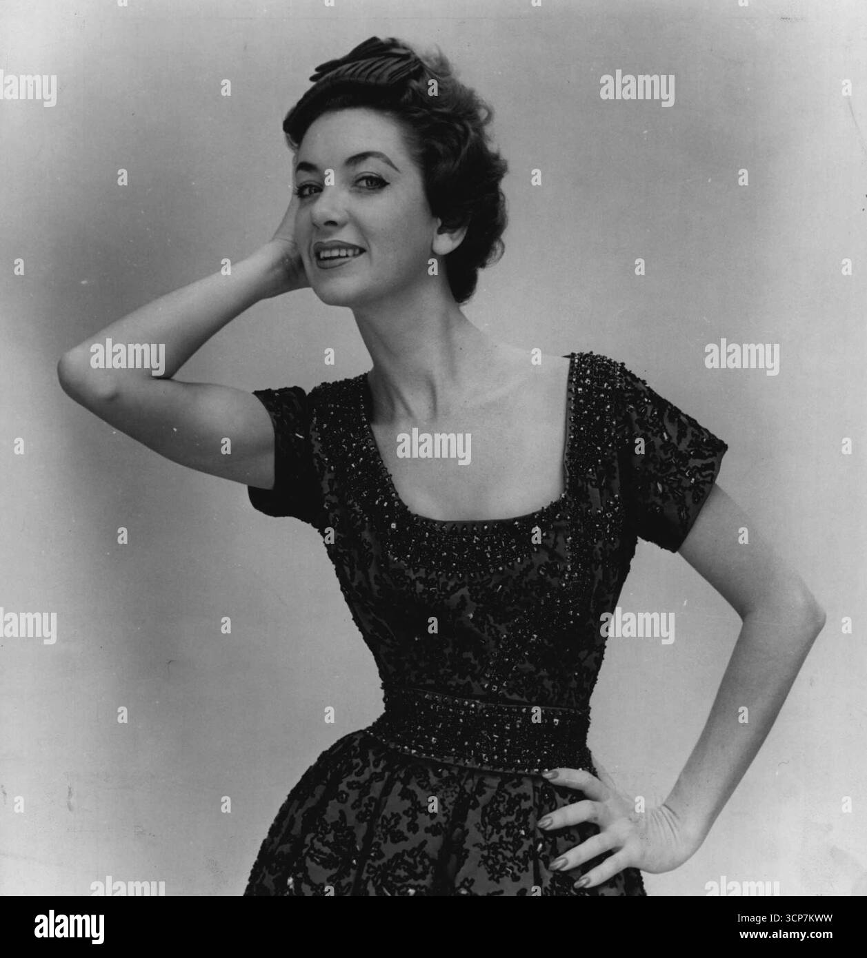 Ricamo ... può essere utilizzato sontuosamente su abiti da sera. La breve camice da sera di Dior, ricca di satin rosso, è interamente ricamata con brillanti blu. Gennaio 29, 1954. Foto Stock