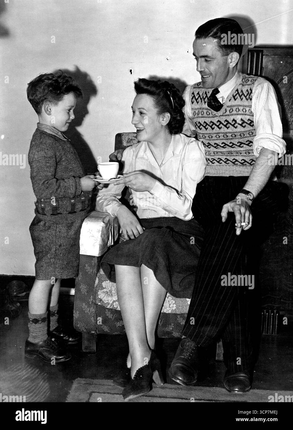 La madre del Quad va a casa -- David Coles, di cinque anni, pronto ad accogliere le sorelle quadruple, saluta sua madre con una tazza di tè Mary Elizabeth Coles, madre dei quattro di Westminster - Marie, Patricia, Frances, Edna, è tornata ieri nel suo appartamento trilocale al quinto piano in Pulford Street, Londra. I quattro rimarranno in ospedale fino a quando non saranno abbastanza forti da andarsene. 16 ottobre 1950. Foto Stock