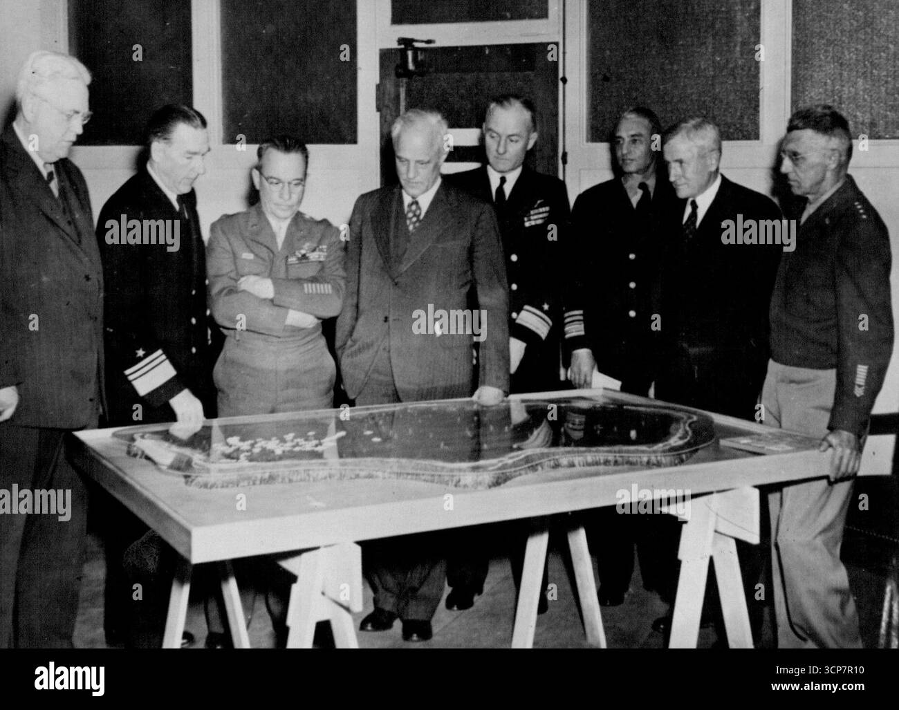 Il Joint Chiefs of staff Evaluation Committee discute l'operazione Crossroads ... il Joint Army-Navy Chiefs of staff Evaluation Committee incontra l'esercito e la marina Joint Task Force One staff conduce a discutere i test delle bombe atomiche in tempo di pace di metà estate nel gruppo dell'atollo Bikini nelle Isole Marshall. Nell'ufficio del viceammiraglio W.H.P. Blandy, comandante della Task Force One, i membri del Comitato di valutazione vedono un modello della laguna dove le bombe saranno sganciate, e uno schema per gli obiettivi navali, da sinistra a destra: Bradley Dewey, presidente della Dewey and Almy Chemical Company, Cambridge, Mass., ***** Sx Foto Stock