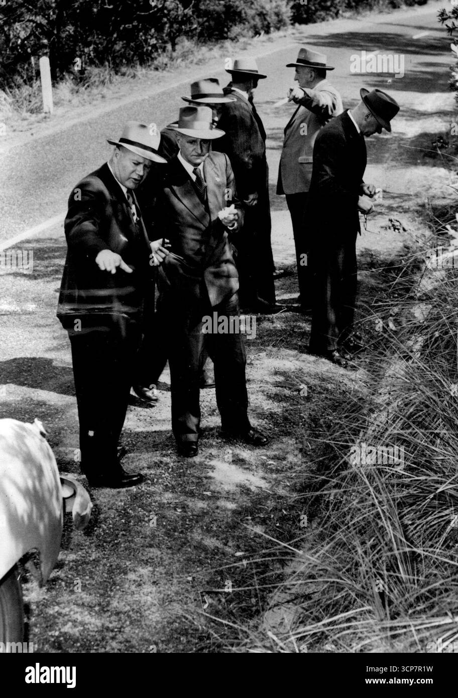 Polizia di alto livello sul lavoro -- conferenza stradale vicino alla scena del delitto questo pomeriggio. In primo piano Det.- Sgt. J. Matthews sta mostrando SUPT. A. Martin dove la ragazza è fuggita dal suo aggressore. Altri nella foto sono Sen.-Det. E. Suttie, INSPECTION-SUPT. A. A. Webster (che nasconde il signor Norman McCallum), First-Const. G. Bishop (mano alzata), e l'ispettore F. Hobley. 9 settembre 1953. Foto Stock