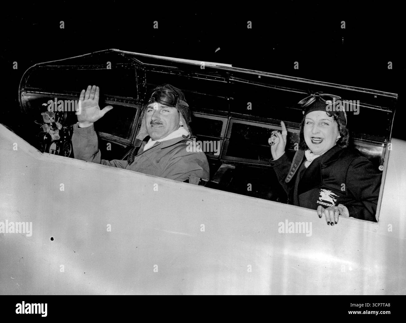 I volantini si preparano a partire per il tentativo di Cape record -- Una fotografia scattata fino alla notte della coppia sul loro aereo a Corydon. L'ufficiale di volo A. E. Clouston e la signora Betty Kirby-Green, hanno fatto i loro ultimi arrangiamenti a Coroydon fino a notte per il tentativo di battere il record Inghilterra -Cape. Si aspettano di iniziare a tarda notte. 14 novembre 1937. (Foto di Keystone). Foto Stock
