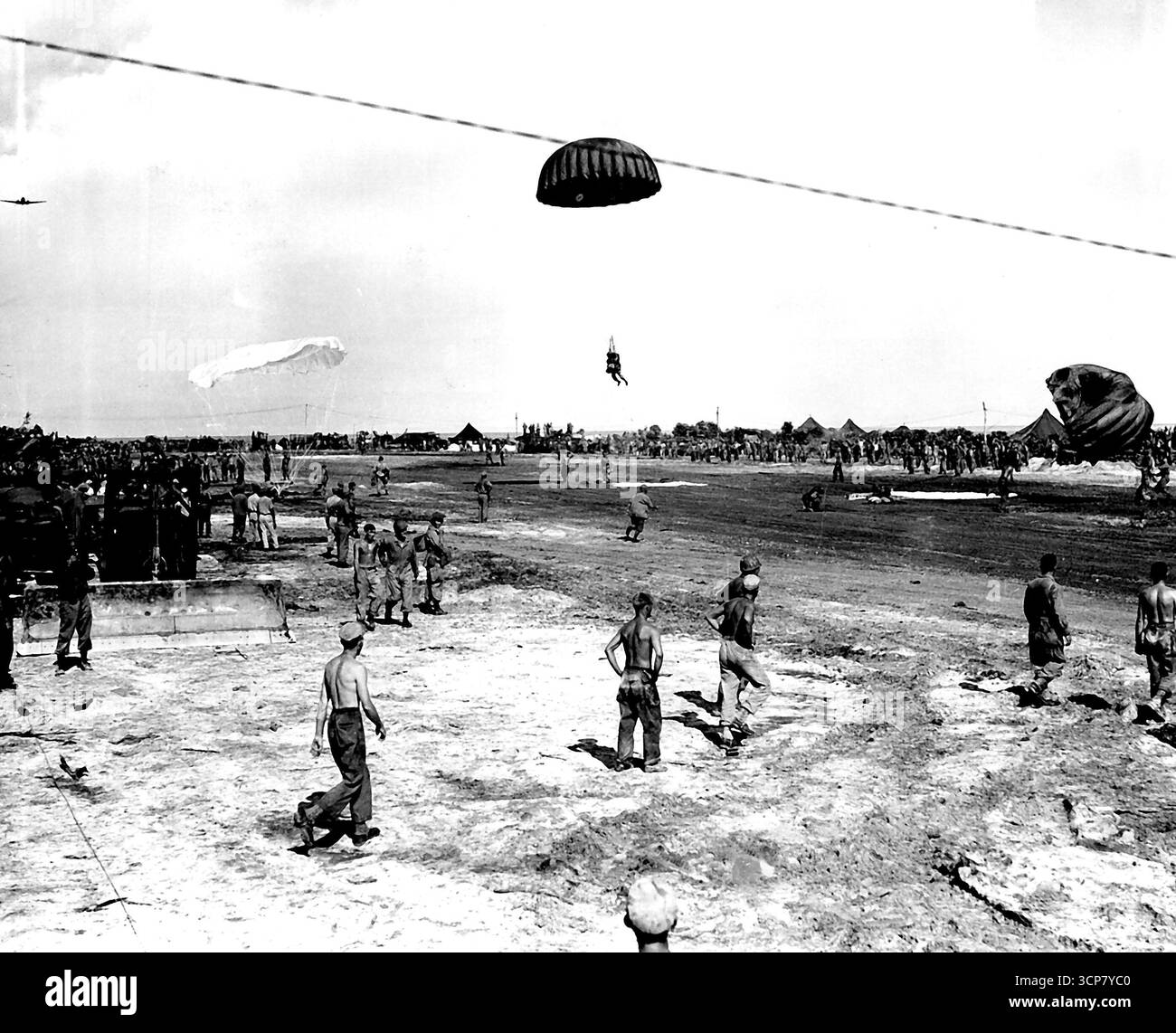 Azione a Noemfoor - i paracadutisti statunitensi hanno interessato gli spettatori per il loro atterraggio sull'isola di Noemfoor, al largo della costa della Nuova Guinea olandese, dove le forze del generale MacArthur hanno cacciato i giapponesi, sequestrando tre campi aerei. Un trooper a destra, sta avendo un po 'di difficoltà con il suo scivolo, mentre un secondo che trasporta l'attrezzatura completa di combattimento, è quasi giù. Luglio 24, 1944. (Foto di Air Department Picture). Foto Stock