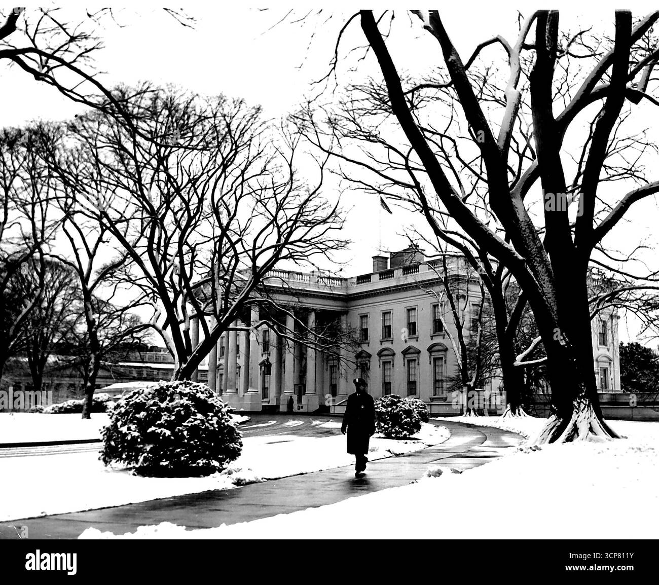 White Washington (terzo di quattro) -- al 1600 di Pennsylvania Avenue, il Cpl. Neve Ralph C. Strover, della polizia della Casa Bianca, pattuglia le passeggiate innevate. 21 gennaio 1955. (Foto di United Press). Foto Stock