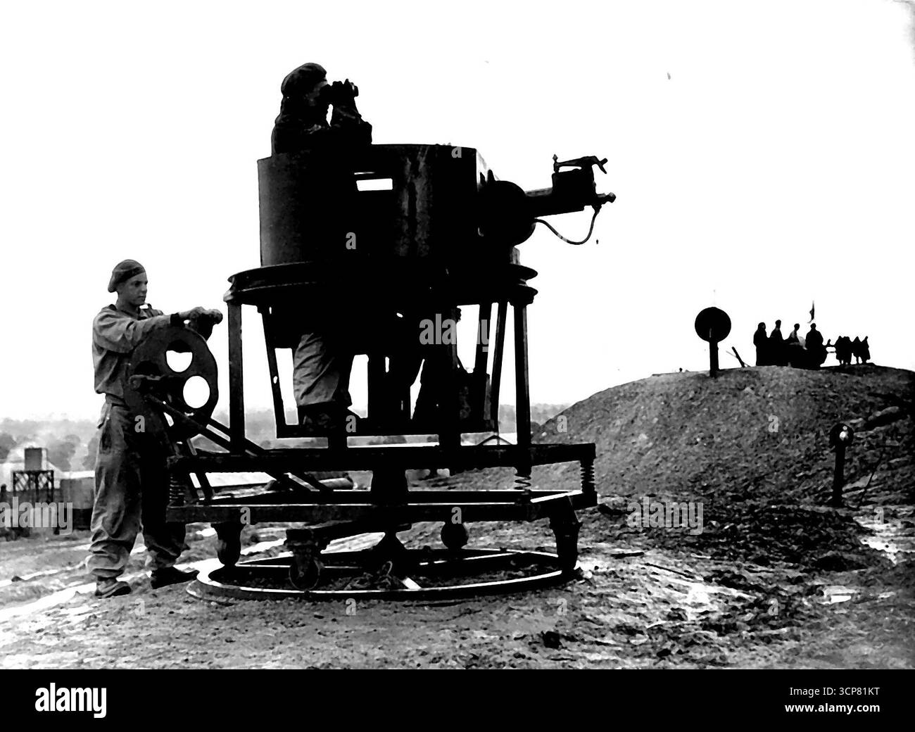 Rocking the Gunner -- questa ingegnosa contesa in un campo di allenamento da qualche parte in Australia si chiama Rypa. È progettato per rappresentare la torretta di un serbatoio, montando una mitragliatrice. L'intera disposizione è montata su molle con una ruota manuale nella parte posteriore per dare alla torretta lo stesso movimento oscillante e irregolare di un serbatoio in azione. Il lavoro del pistolero è reso più difficile perché sta sparando contro un bersaglio in movimento. Consente di risparmiare usura sui carri armati e di risparmiare sull'uso di munizioni di piccolo calibro. 3 settembre 1942. Foto Stock