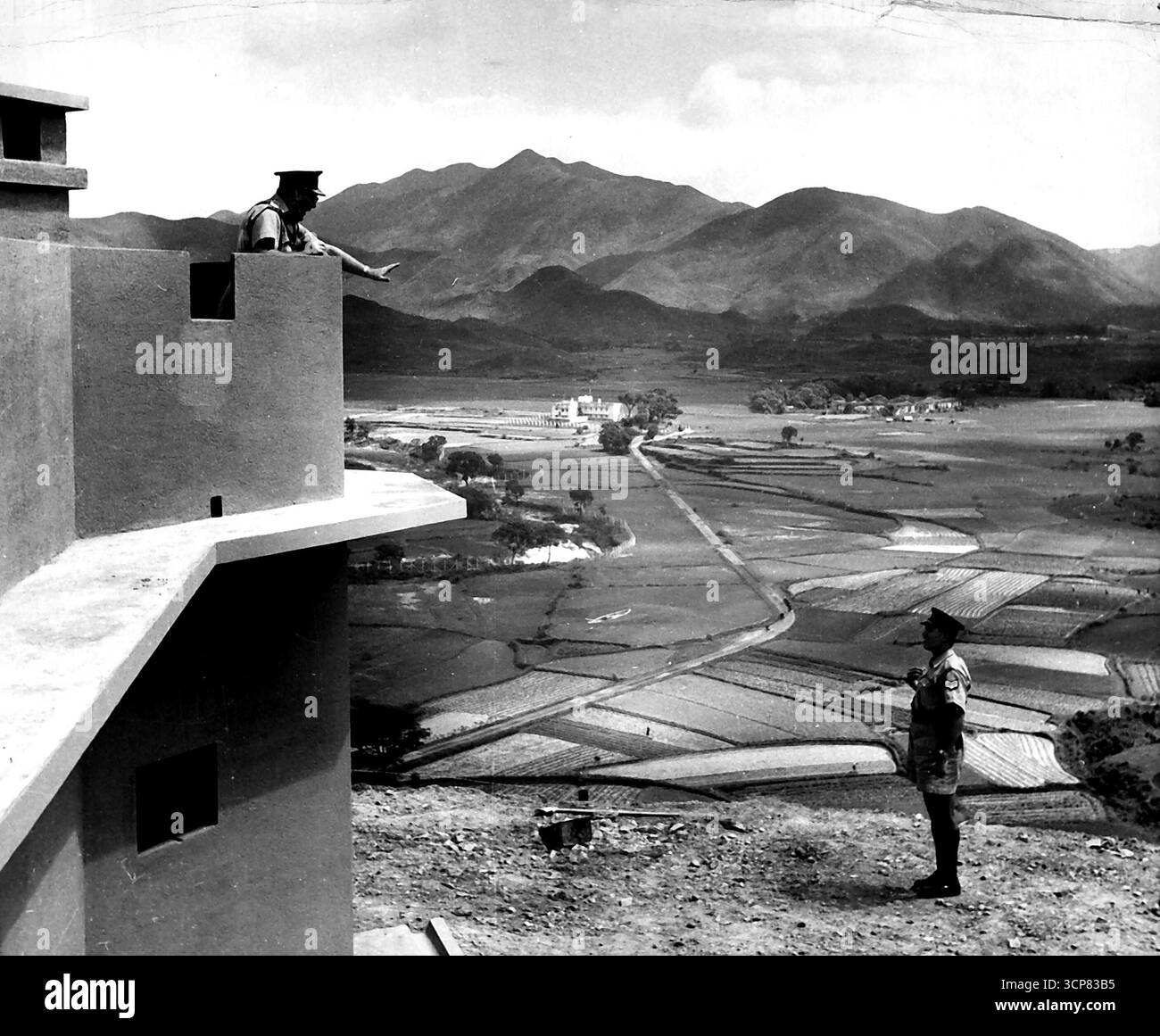 Collo di bottiglia della cortina di ferro -- il piccolo fiume Winding può essere visto proprio alla destra del punto di osservazione che offre una vista eccellente della linea di divisione. Anche se ci sono alcuni campi, la maggior parte del territorio di Hong Kong si trova su Rocky Ground, non adatto per allevare il grosso dei generi alimentari necessari per la colonia. 27 ottobre 1950. (Foto di ACME). Foto Stock