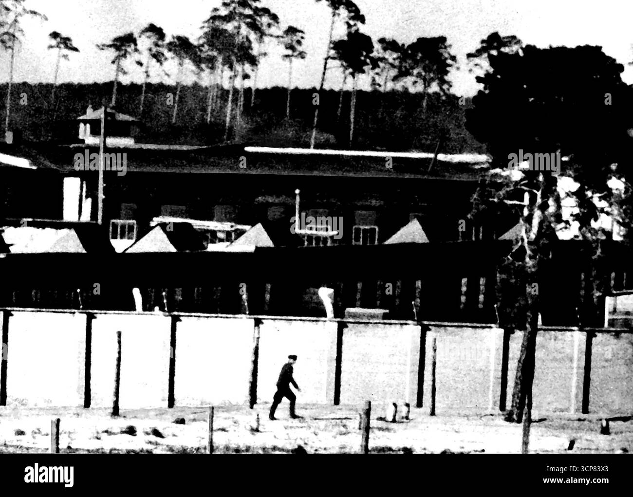 Immagini del campo di concentramento sovietico. I russi rianimano il famigerato Sachsenhausen -- Un ufficiale russo si aggira intorno al campo di Sachsenhausen. Queste immagini sono state realizzate con una fotocamera da 35 mm con un obiettivo da 40 centimetri. Queste prime foto del campo di Sachsenhausen governato dai sovietici furono scattate, a rischio della sua vita, da un fotografo - deliberatamente non identificato - che accovacciato tra lapidi a duecento metri da tiratori e mitragliatori russi. Secondo i rapporti ci sono circa 14.500 uomini e 1.500 donne internati a Sachsenhausen, famigerato sotto i nazisti, ora gestiti dal so Foto Stock