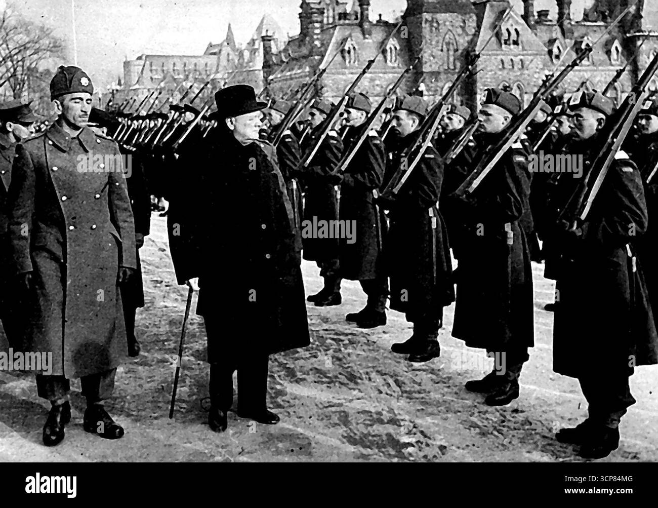La visita canadese del signor Churchill -- il primo ministro britannico a Ottawa il signor Churchill arrivò a Washington nella capitale canadese Ottawa il 29 dicembre e consegnò il suo storico discorso davanti ai membri riuniti della legislatura Canandiana alla camera dei comuni il giorno seguente. Il signor Churchill ispeziona una guardia d'onore fornita dall'esercito canadese, fuori dagli edifici del Parlamento, Ottawa. 9 gennaio 1942. (Foto del British Official War Office Photo). Foto Stock