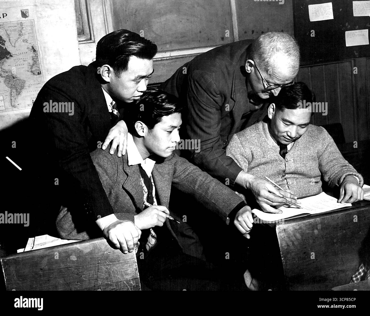 Gli studenti cinesi hanno più difficoltà a imparare l'inglese rispetto ai loro compagni di classe europei, abituati all'alfabeto simile al loro. Da sinistra: Giovane di Nanchino (commerciante di frutta), Kai Shawng Kwok, Hong Kong (negozio), M.H.L.B. Hodge, insegnante, Wong Hong, Hong Kong (importatore). 1° agosto 1947. Foto Stock