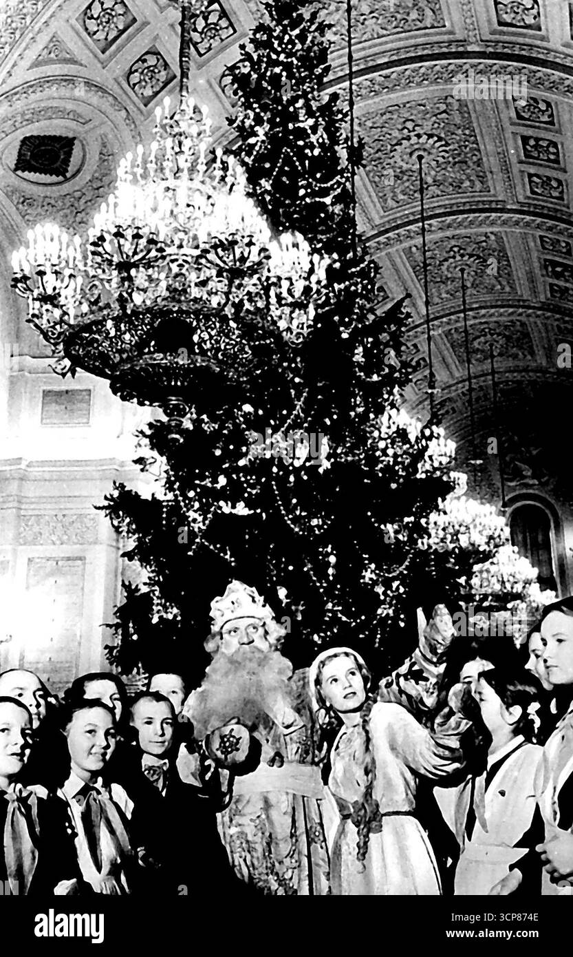Tempo gay al Cremlino a Capodanno - questa è una delle prime foto di una delle feste del Cremlino a cui hanno partecipato bambini provenienti da tutta Mosca. Ognuno ha ricevuto un dono, arance e mandarini da padre Frost. L'equivalente tradizionale russo di Babbo Natale. La fanciulla delle nevi, un altro personaggio tradizionale visto in questa foto, lo aiutò a illuminare le luci sull'abete gigante. Per la prima volta in assoluto, alcune delle tante feste di Capodanno per bambini di Mosca si svolgono quest'anno nel Cremlino. 15 gennaio 1954. (Foto di Associated Press Photo). Foto Stock