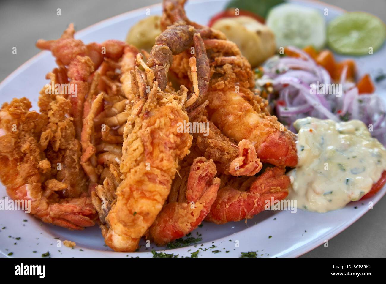 Dorate e croccanti, le fritte di camarones peruviane catturano l'essenza del sapore costiero: Gamberi freschi fritti alla perfezione, croccanti all'esterno e teneri Foto Stock