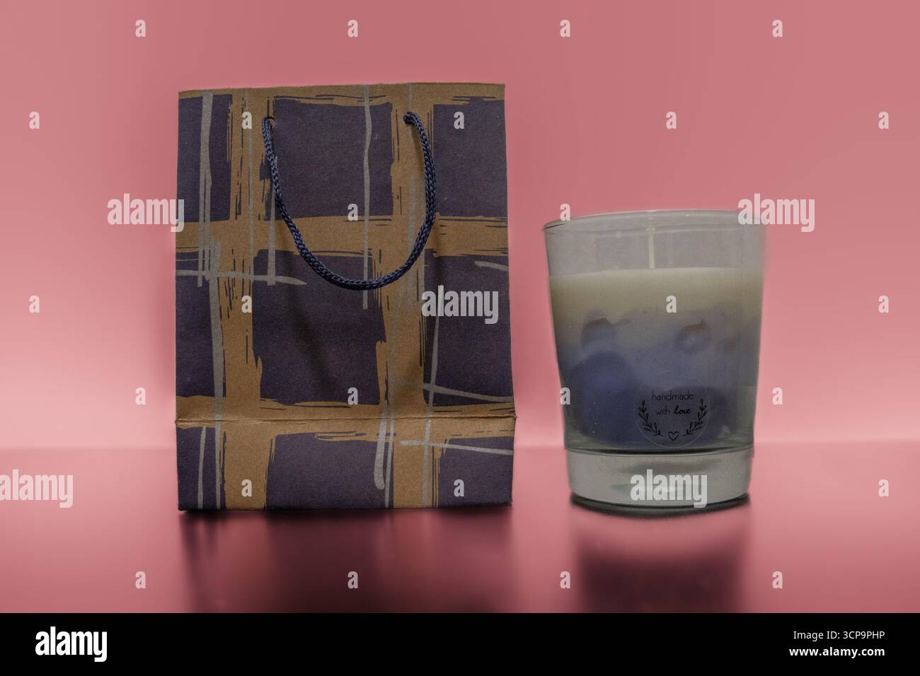 Foto di prodotto di candele versate a mano in contenitori di vetro, design minimalista per l'arredamento e il relax della casa, scattate su sfondo. Foto Stock