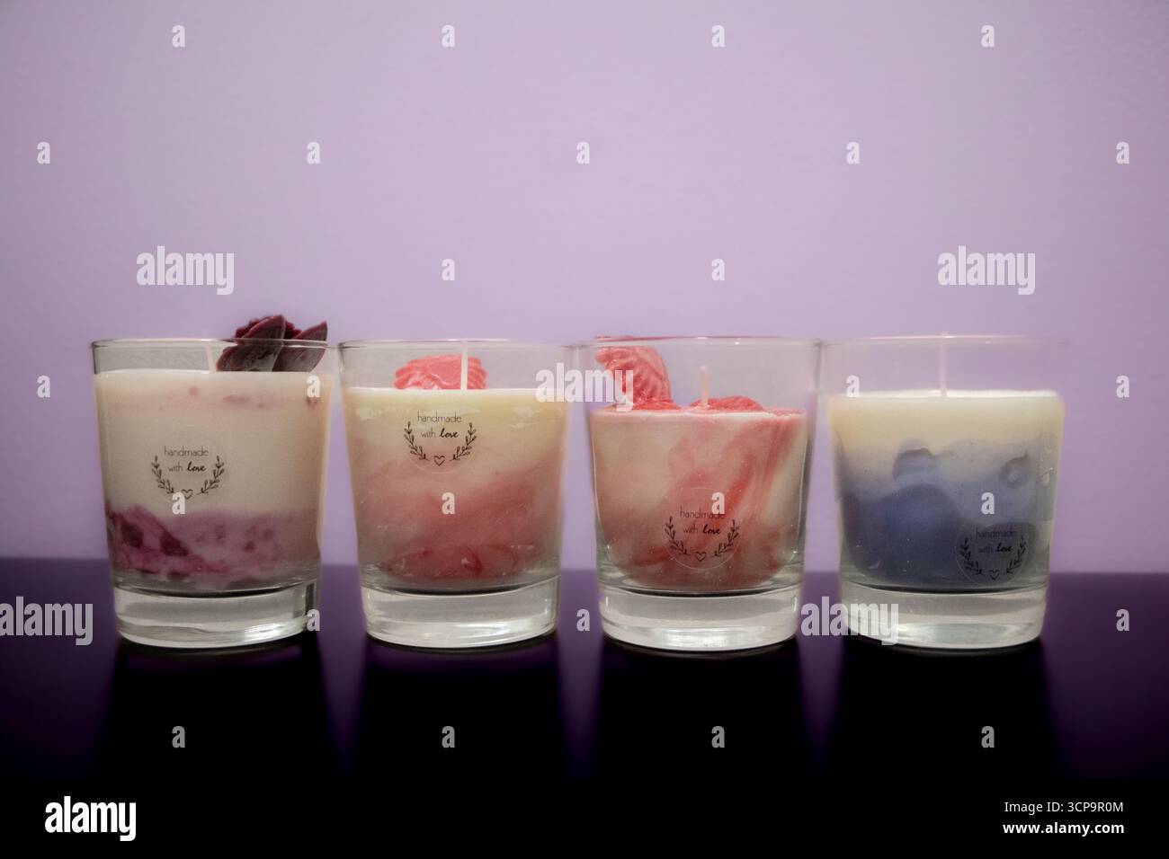 Foto di prodotto di candele versate a mano in contenitori di vetro, design minimalista per l'arredamento e il relax della casa, scattate su sfondo. Foto Stock