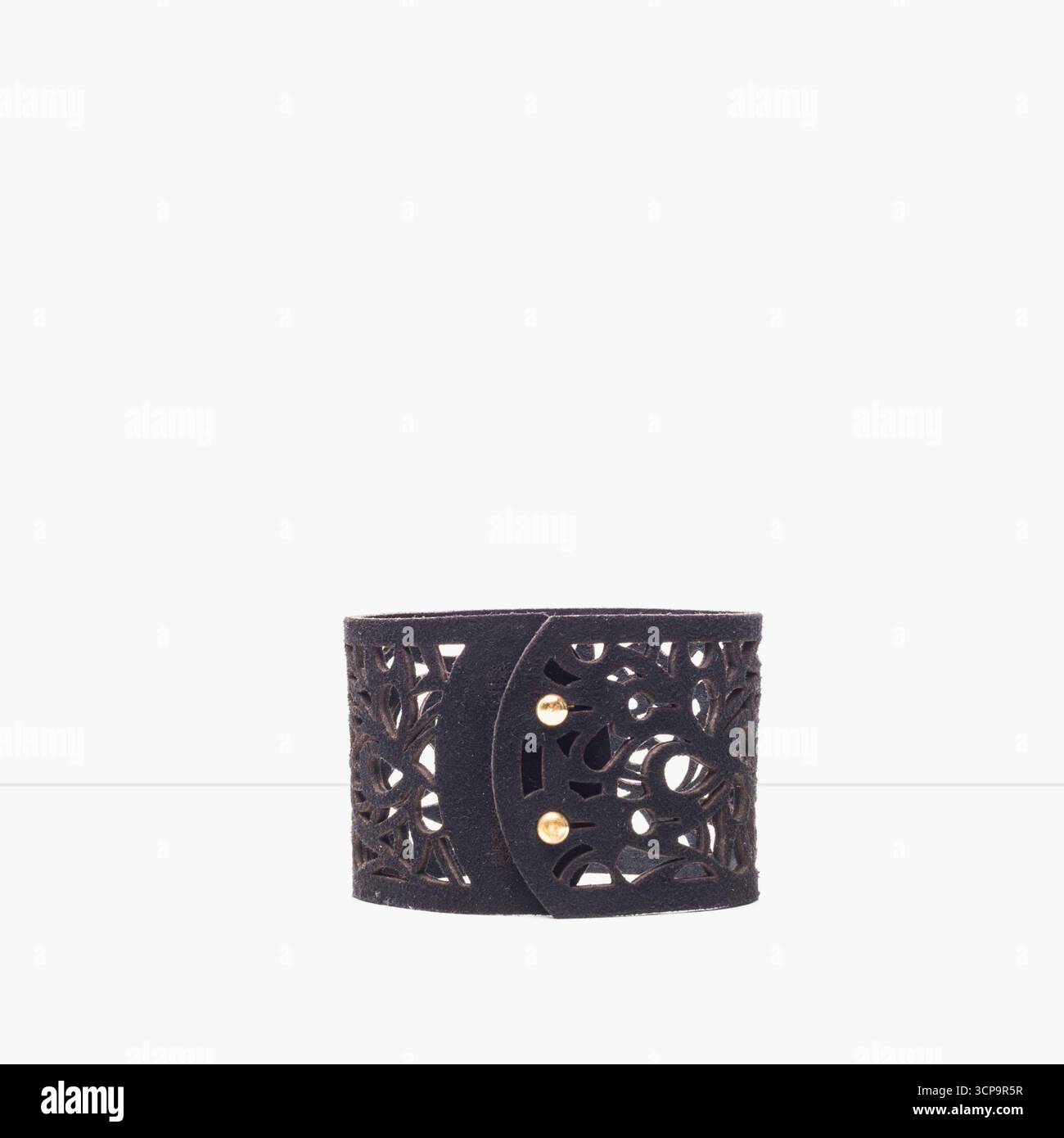 Bracciale a polsini decorativo nero con un design dalle linee intricate e dettagli dorati Foto Stock
