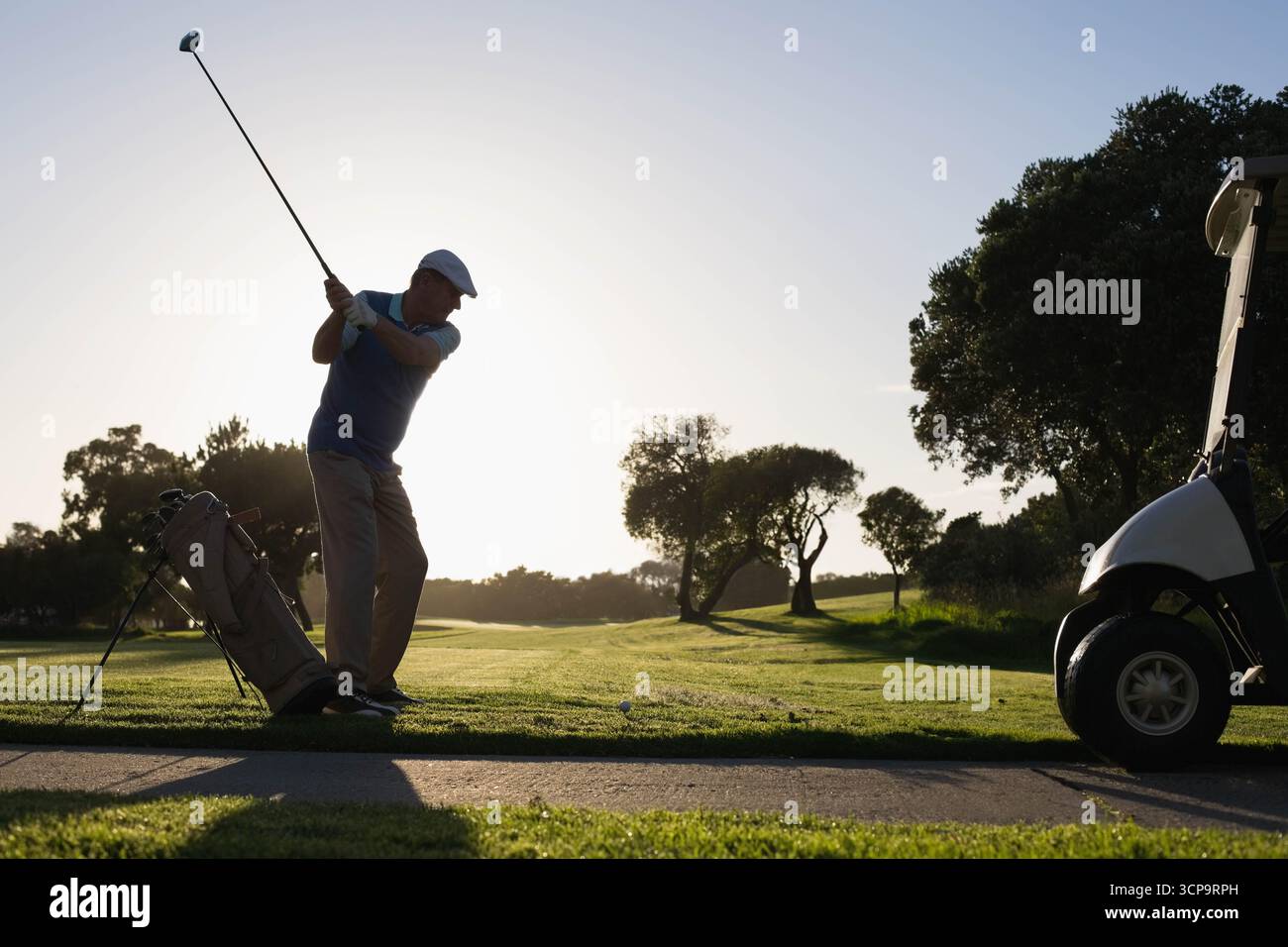 Golf club senior con pilota oscillante presso il tee box sul campo da golf che mira alla palla da golf, spazio fotocopie Foto Stock