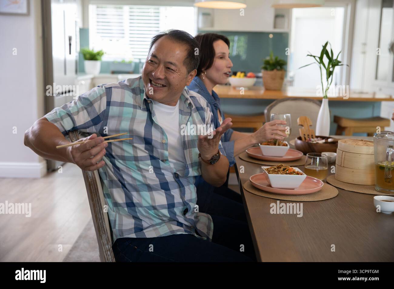Diverse coppie anziane sedute e mangiate spaghetti con bacchette al tavolo da pranzo, spazio per fotocopie Foto Stock